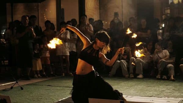 A FlowFinch fire performance before a seated audience.